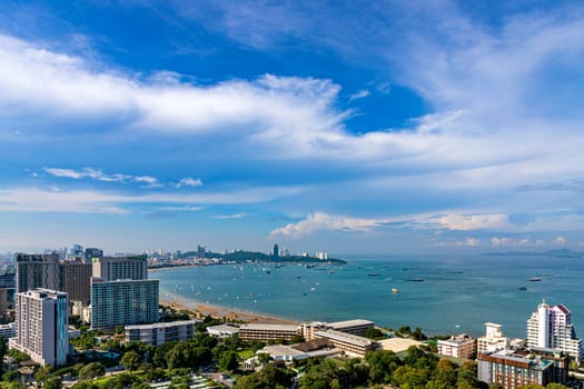 Chonburi, Thailand - 26 Oct. 2023 Morning view of Pattaya sea Saw many accommodations, both tall and low-rise buildings. There are many trees. Sea level has receded until you can see a sandy beach.