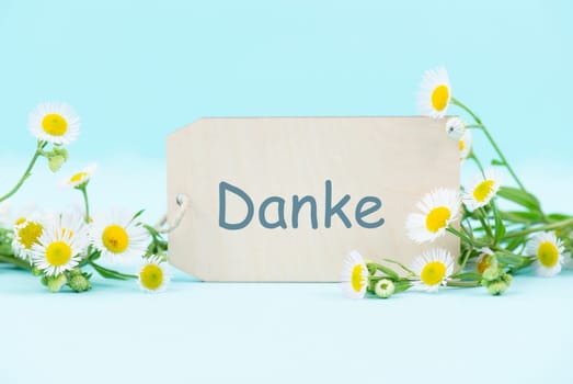 Thanks card surrounded by flowers, german language, being thankful, support, help and charity concept, positive attitude