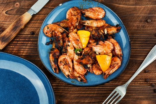 Roasted unpeeled shrimp on a plate. Grilled prawns or shrimps, seafood.