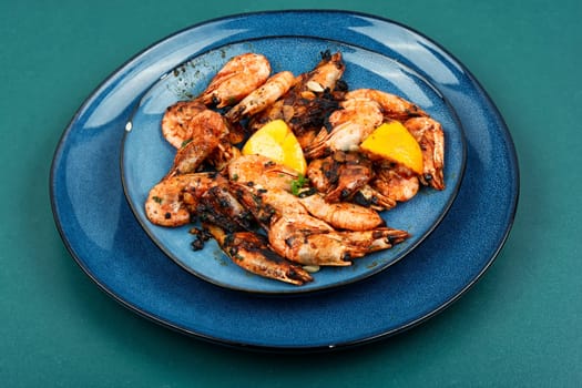 Roasted unpeeled shrimp on a plate. Grilled prawns or shrimps, seafood.