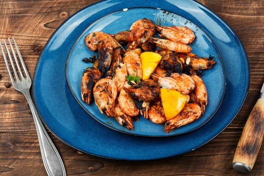 Roasted unpeeled shrimp on a plate. Grilled prawns or shrimps, seafood.
