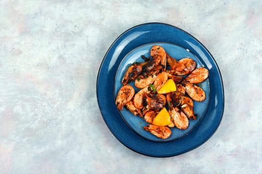 Roasted unpeeled shrimp on a plate. Grilled prawns or shrimps, seafood.