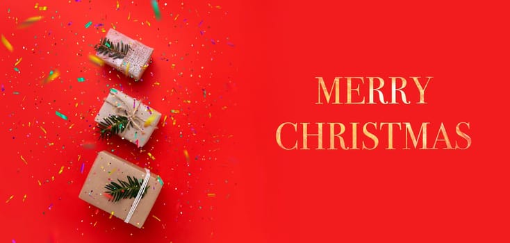 three boxes with gifts on a bright red background and the inscription Merry Christmas. selective focus .High quality photo