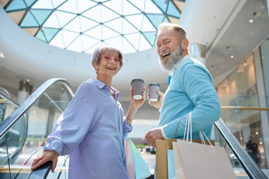 Adult senior couple with purchases having fun time at shopping mall. Weekends on retirement concept