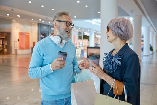 Retired people spending time in city shopping center. Elderly wife shopaholic asking loving husband for more purchases