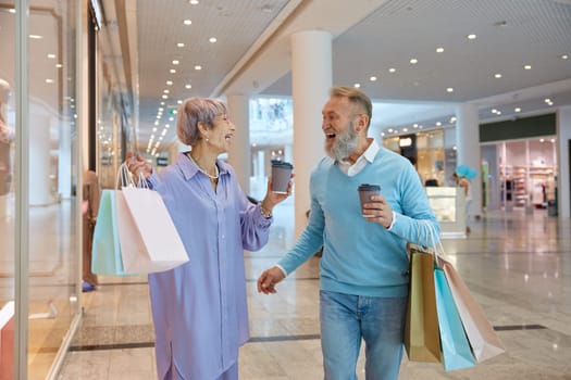 Overjoyed senior couple with shopping bags rejoicing successful purchases during Black Friday sale