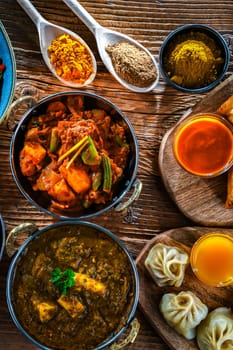Composition with indian dishes: samosa, pakora, palak paneer, jalfrezi, thukpa and naan bread