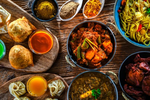 Composition with indian dishes: samosa, pakora, palak paneer, jalfrezi, thukpa and naan bread