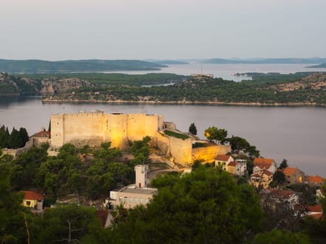Illuminated St. Michael's Fortress and city buildings at dusk, Sibenik, Sibenik-Knin, Croatia