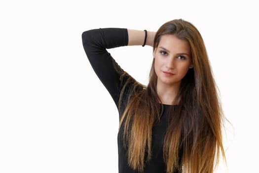 Studio portrait of attractive girl holding her long hair on the light background. Horizontally.