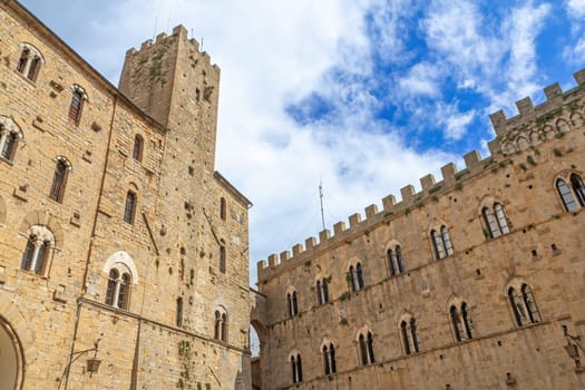 Houses in the Tuscan town of Volterra with a blue sky with clouds in the background. Tuscany, Italy.