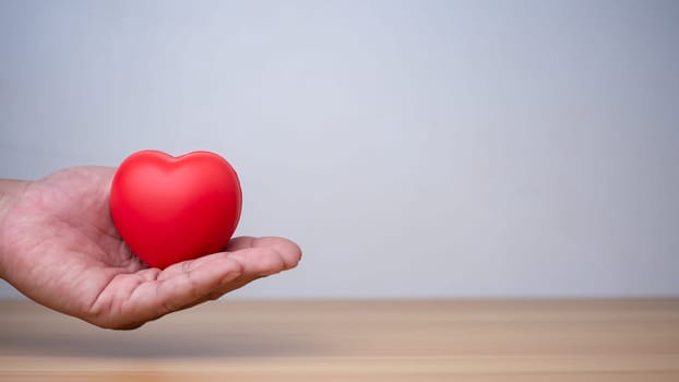 Good health and insurance concept, health insurance concept. Human hand holding red heart.