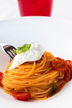 Italian pasta - spaghetti with burrata cheese closeup, mediterranean diet