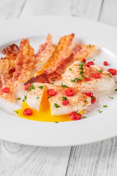 Portion of chili poached eggs with crispy bacon
