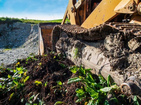 Side view of the crawler track of a bulldozer contaminated with soil.