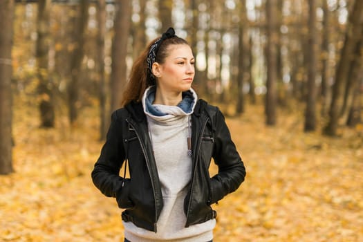 Outdoor atmospheric lifestyle portrait of young beautiful young woman. Warm autumn fall season copy space