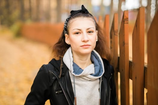 Outdoor atmospheric lifestyle portrait of young beautiful young woman copy space. Warm autumn fall season. Millennial generation and youth.