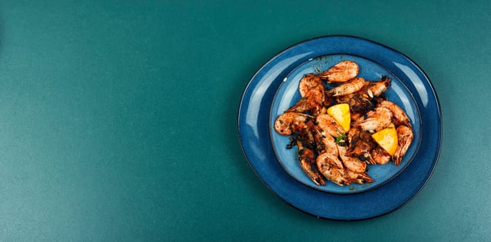 Fried unpeeled shrimp on a plate. Roast prawns shrimps.