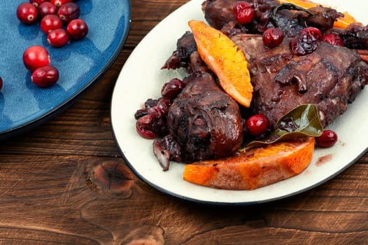 Grilled spicy chicken legs baked with orange, spices and red berries.
