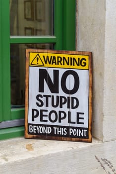 Shield saying No stupid people allowed beyond this point