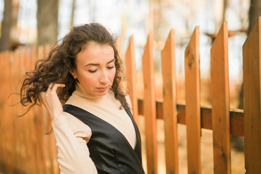 Autumn portrait of a beautiful happy curly woman in fall season. Millennial generation female. Natural beauty
