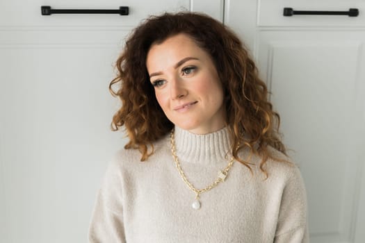 Close-up female in modern gold metal necklace chain with pearl pendant.