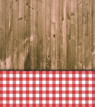 Old weathered wooden wall with red and and white checkered tablecloth