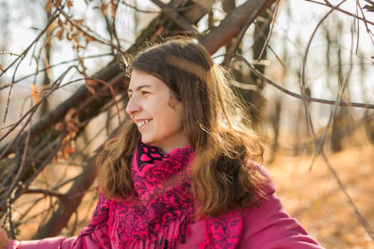 Beautiful happy smiling girl with long hair wearing black hat and pink jacket posing in autumn park. Outdoor portrait day light. Autumn mood concept. Copy empty space for text.