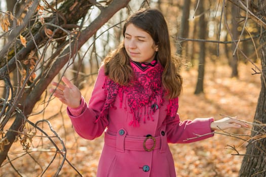 Beautiful happy smiling girl with long hair wearing black hat and pink jacket posing in autumn park. Outdoor portrait day light. Autumn mood concept. Copy empty space for text.