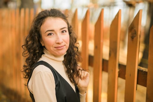 Autumn portrait of a beautiful happy curly woman in fall season. Millennial generation female. Natural beauty