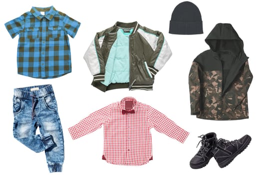 Collage set of little boys autumn clothes isolated on a white background. Denim trousers and jacket, boots, a down jacket, pants and hood for child boy. Children's winter fashion.