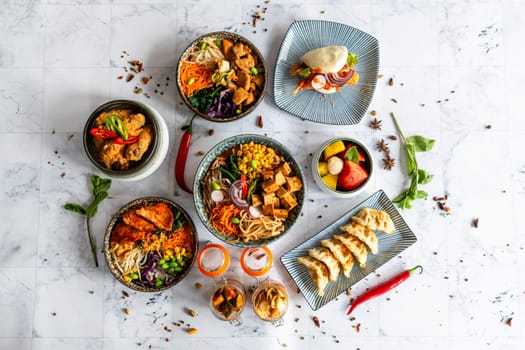 An assortment of well-served Chinese food. Chinese noodles, fried rice, dumplings, pedestrian duck, dim sum, spring rolls. Famous Chinese cuisine on the table. View from above. Chinese restaurant concept. Asian banquet
