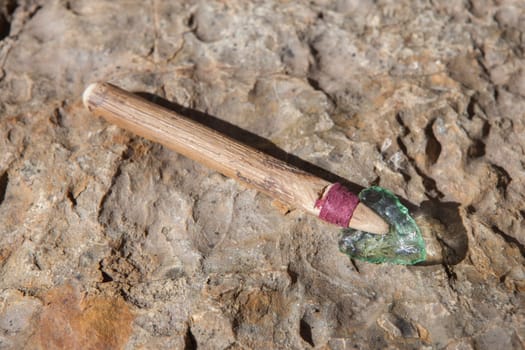 Prehistorical arrowhead built in short shaft. Replica made of glass for educational purposes