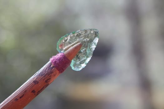 Prehistorical arrowhead built in short shaft. Replica made of glass for educational purposes