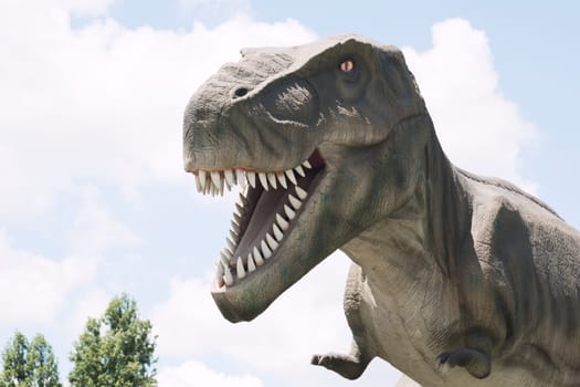 The ancient extinct predator tyrannosaurus rex dinosaur is on cloudy sky background.