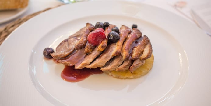 Iberian sirloin fillets cooked with autumn fruits. Plate served over rattan mat