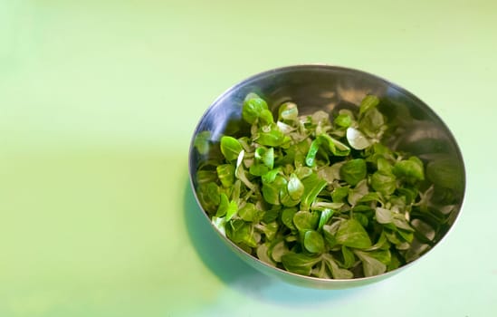 Metallic bowl full of corn salad. Turquoise background