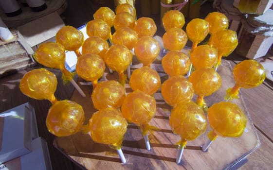 Honey lollipops displayed in a traditional market stall. Healthy candy concept