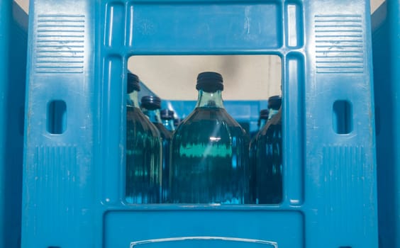 Glass bottled water on his blue box. Selective focus