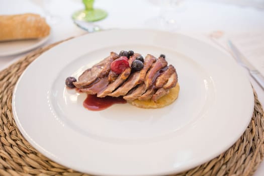 Iberian sirloin fillets cooked with autumn fruits. Plate served over rattan mat