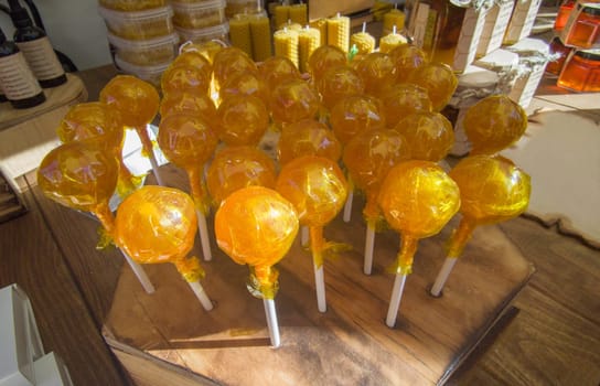 Honey lollipops displayed in a traditional market stall. Healthy candy concept