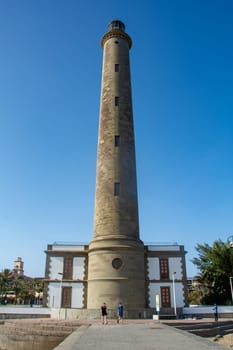 Lighthouse in Maspalomas ( Faro de Maspalomas ) on the Canary Island of Gran Canaria in Spain with palm tree