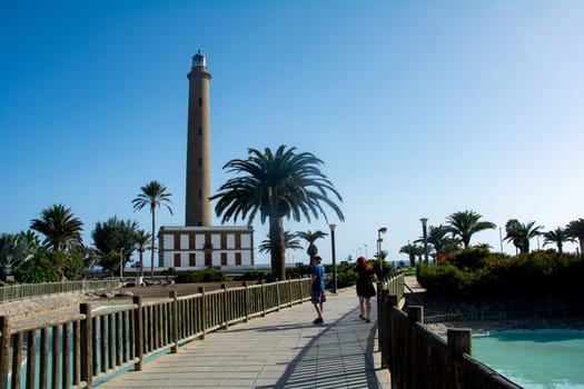 Lighthouse in Maspalomas ( Faro de Maspalomas ) on the Canary Island of Gran Canaria in Spain with palm tree