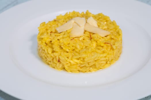 Portion of saffron risotto on the white plate