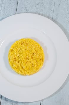 Portion of saffron risotto on the white plate