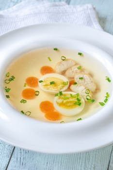 Portion of clear chicken broth in white plate