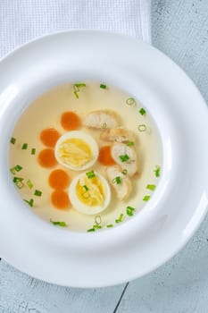 Portion of clear chicken broth in white plate