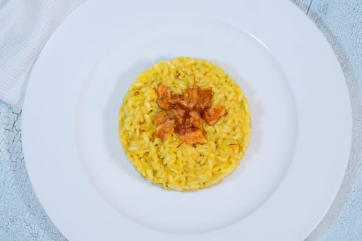 Portion of saffron risotto garnished with pancetta