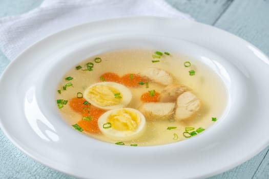 Portion of clear chicken broth in white plate