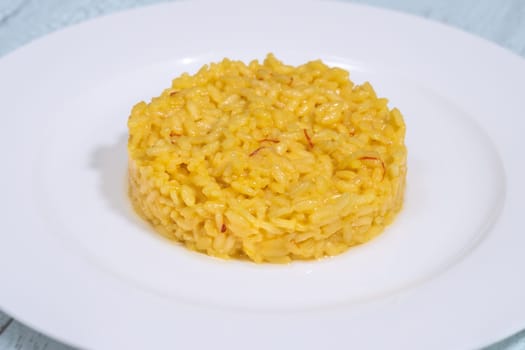 Portion of saffron risotto on the white plate